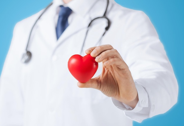 healthcare and medical concept - male doctor with heart