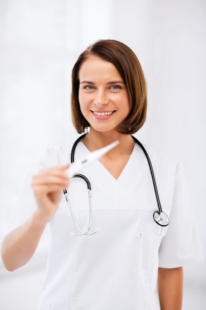 healthcare and medical - female doctor with thermometer and stethoscope.