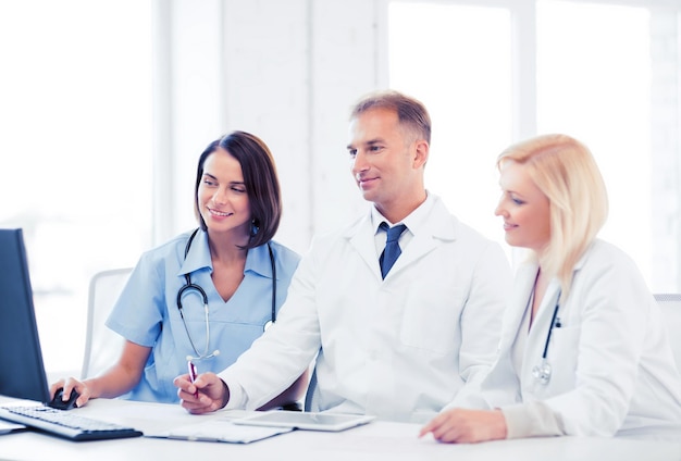 healthcare, medical and technology - group of doctors looking at computer on meeting