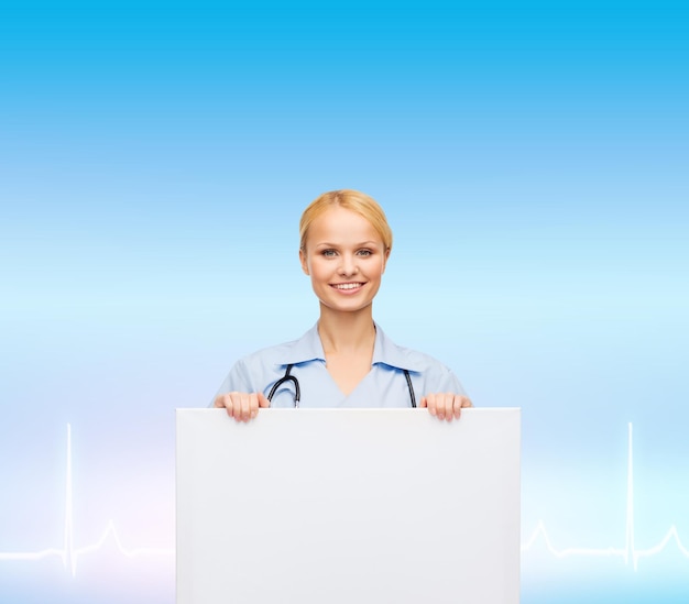 healthcare, medicine, advertisement and sale concept - smiling female doctor or nurse with stethoscope and white blank board