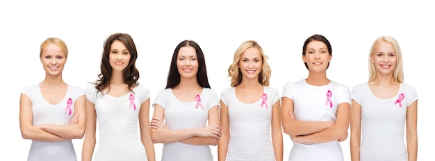 의료 및 의학 개념 - 분홍색 유방암 인식 리본이 달린 빈 티셔츠를 입은 웃고 있는 여성들