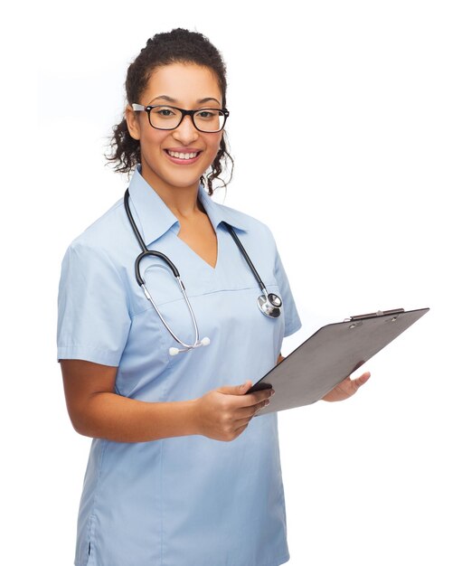 healthcare and medicine concept - smiling female african american doctor or nurse in eyeglasses with stethoscope and clipboard