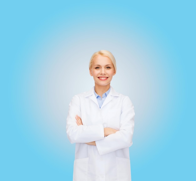 концепция здравоохранения и медицины - улыбающаяся женщина-врач на синем фоне