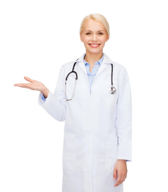 healthcare and medicine concept - smiling female doctor holding something on palm of her hand