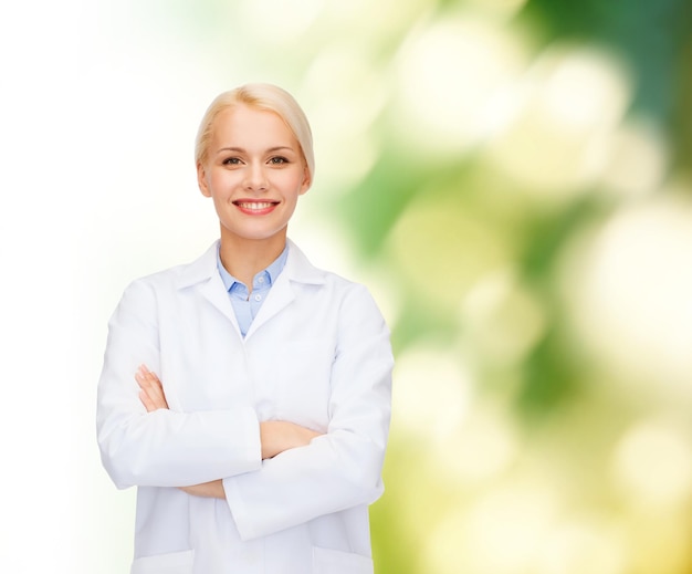 healthcare and medicine concept - smiling female doctor over natural background