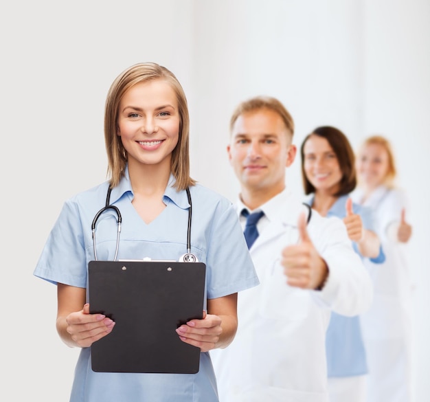 의료 및 의학 개념 - 클립보드와 청진기를 들고 웃는 여성 의사 또는 간호사