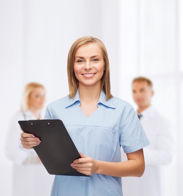 healthcare and medicine concept - smiling female doctor or nurse with clipboard