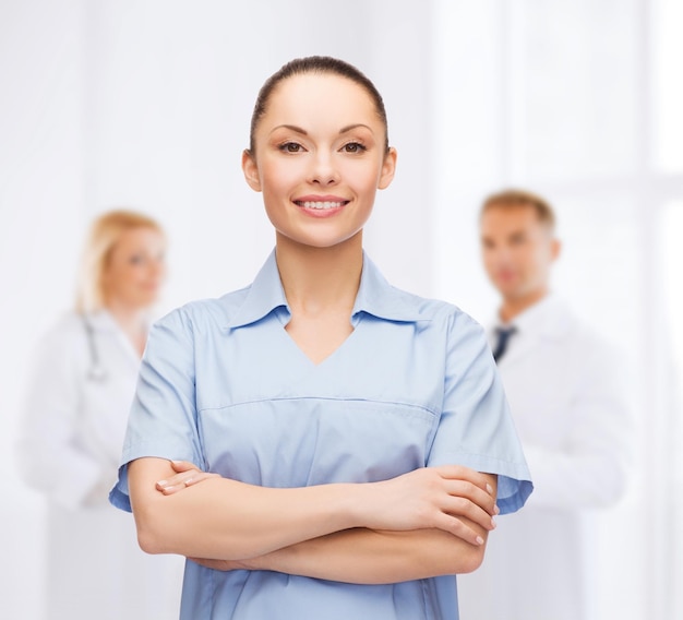 концепция здравоохранения и медицины - улыбающаяся женщина-врач или медсестра
