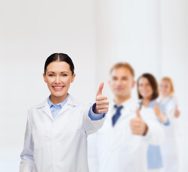 healthcare and medicine concept - smiling female doctor showing thumbs up