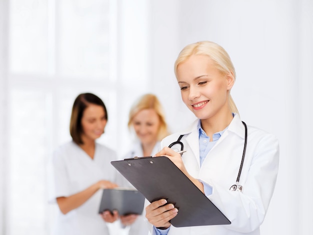 healthcare and medicine concept - smiling female doctor with stethoscope and clipboard