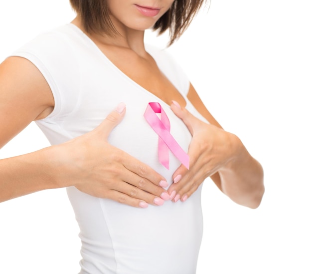 healthcare and medicine concept - woman in blank t-shirt with pink breast cancer awareness ribbon checking breast