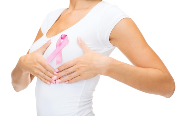 healthcare and medicine concept - woman in blank t-shirt with pink breast cancer awareness ribbon checking breast