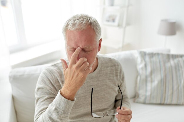 의료, 통증, 스트레스, 연령 및 사람 개념 - 집에서 두통으로 고통받는 노인