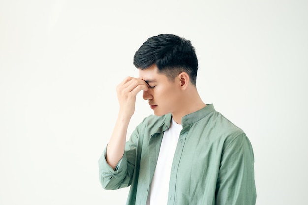 건강 관리 고통 스트레스 나이와 사람들의 개념 흰색 배경에 두통으로 고통받는 젊은 아시아 남자