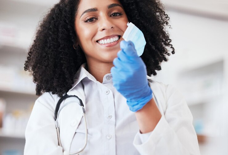 Photo healthcare portrait and doctor remove mask or medical worker with freedom safety or smile african person career in medicine with facial ppe for virus end protection or professional hospital care