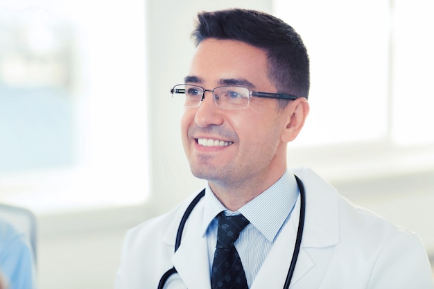 医療,職業,医学の概念 - 病院で白いコートと眼鏡をかぶった笑顔の男性医師