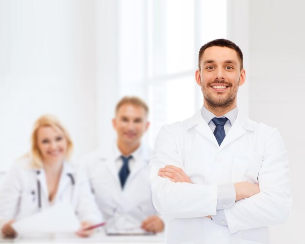 의료, 직업 및 의학 개념 - 흰색 배경 위에 흰색 코트를 입은 웃는 남성 의사