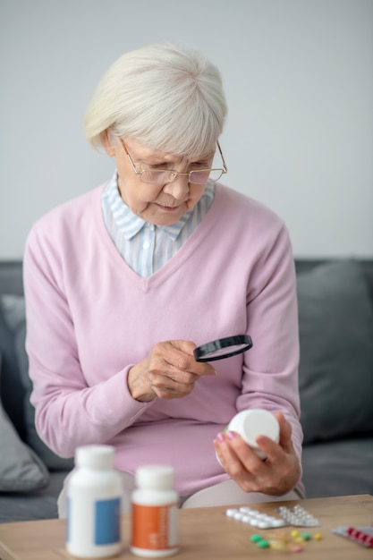 Healthcare. Senior woman with poor vision scrutinizing the medicines