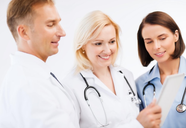 healthcare and technology concept - doctors looking at tablet pc