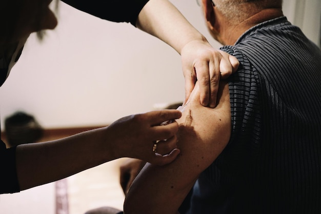 Healthcare worker injecting syringe on arm of patient