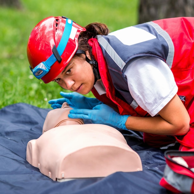 Foto un operatore sanitario si esercita su un manichino di rianimazione cardiaca nel parco