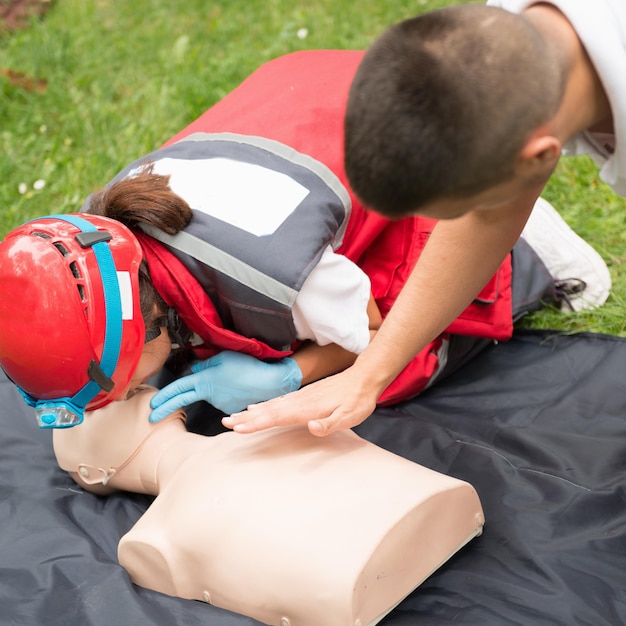 Photo healthcare workers practicing on cpr dummy at park