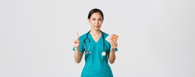 Healthcare workers, preventing virus, quarantine campaign concept. Reluctant and disappointed asian female physician, doctor shaking finger in disapproval, scolding patient for taking medication.