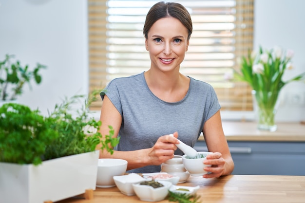 Donna adulta in buona salute che fa cosmetici naturali a casa