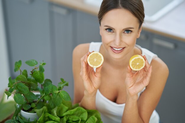 healthy adult woman with green food in the kitchen