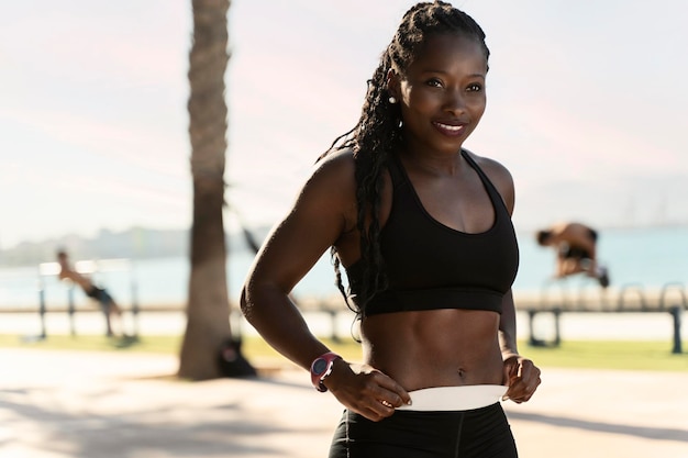 Здоровая африканская американка готовится делать упражнения на пляже