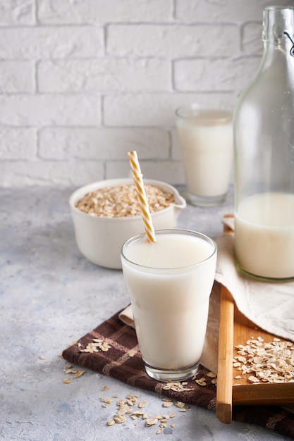 Healthy alternative milk. Homemade oak milk in glass and bottle on light table Lactose free