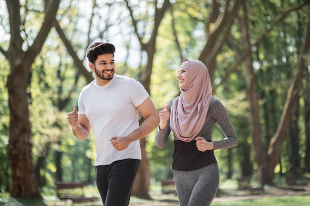 Healthy arabian couple enjoying morning run at green park