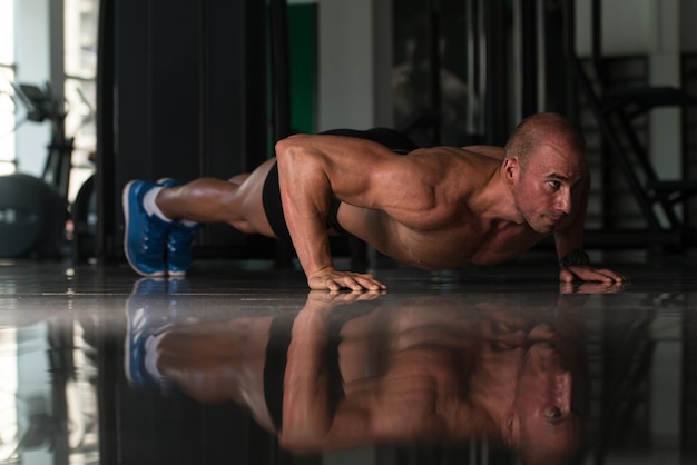 Фото Здоровый спортсмен делает отжимания в рамках тренировки по бодибилдингу