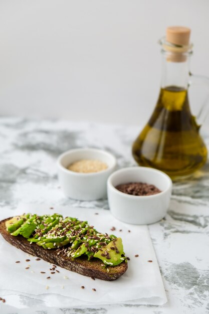 Healthy avocado toast on concrete background. Wholegrain bread, sesame flax seeds olive oil. Vegan keto diet. Healthy eating. Vegetarian Trendy guacamole sandwich.