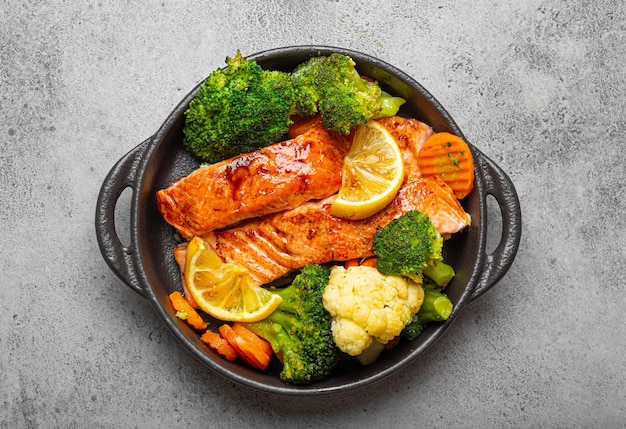 Healthy baked fish salmon steaks broccoli cauliflower carrot