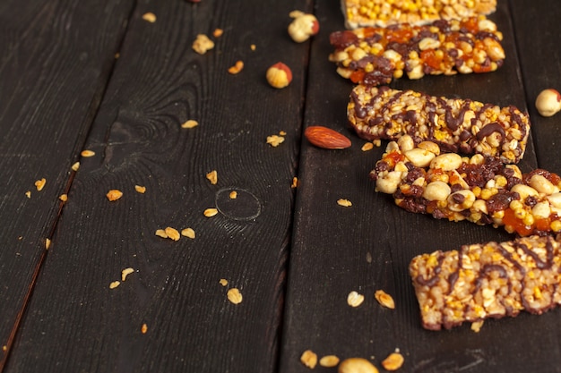 Healthy bars with nuts, seeds and dried fruits on the wooden table