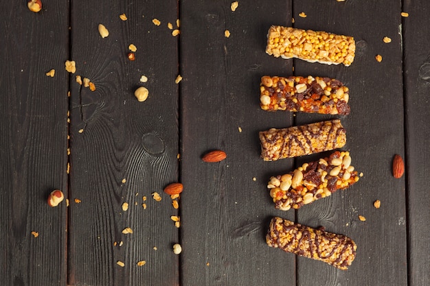 Healthy bars with nuts, seeds and dried fruits on the wooden table