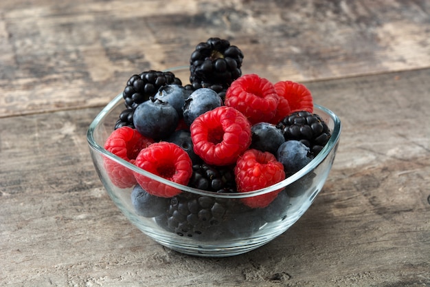 healthy berries in bowl on wooden table