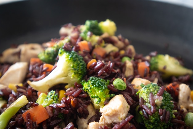 Healthy black fired rice chicken breast on hot pan.