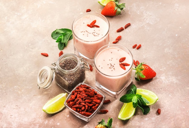 Healthy blended diet smoothie drink with strawberry and goji berries chia seeds and lime Top view