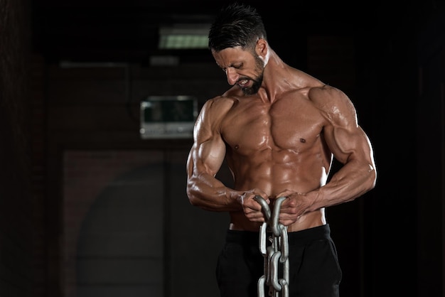 Healthy Bodybuilder Exercising Biceps With Chains