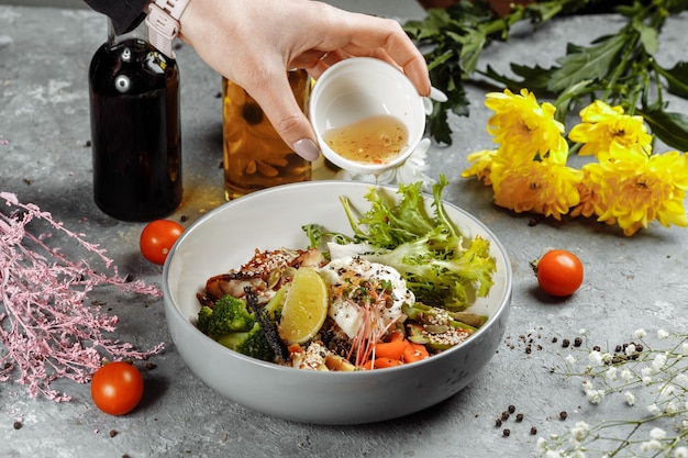 Ciotola sana insalata di quinoa con tonno broccoli avocado su tavola rustica in legno vista dall'alto