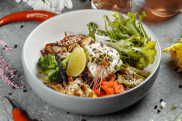 Healthy bowl quinoa salad with tuna broccoli avocado on wooden rustic table top view