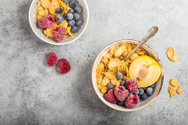 Healthy breakfast bowl, cereals, fresh fruit, berries on table. Clean eating, diet concept.