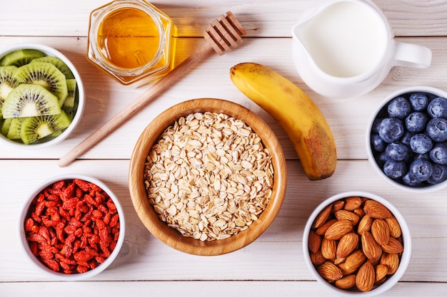 Healthy breakfast bowl of oat flakes with fresh fruit, almond and honey