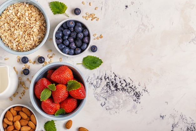 Healthy breakfast - a bowl of oatmeal, berries and fruit, top view.