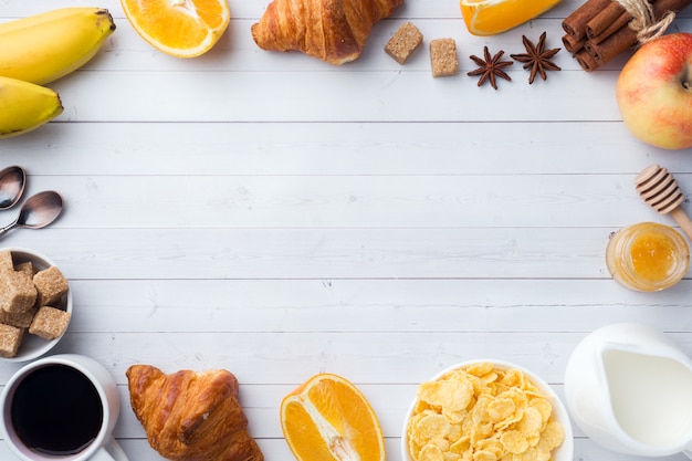 Photo healthy breakfast of coffee croissants, milk, honey and fruit. balanced diet. copy space
