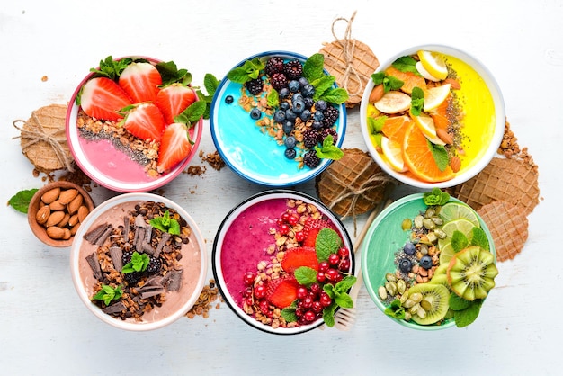 A healthy breakfast. Colorful fruit smoothies with yogurt, fresh fruit and berries. Top view. Free space for your text. On a white background.