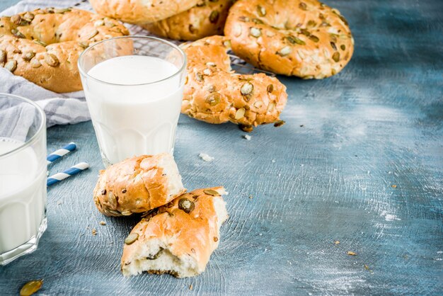 Healthy breakfast concept, home made cereal bagels with milk glass, on blue background