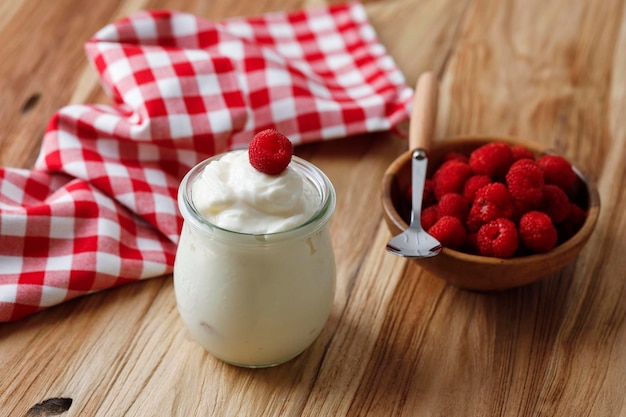 Concetto di colazione sana yogurt greco naturale con frutti di bosco freschi sullo sfondo di legno